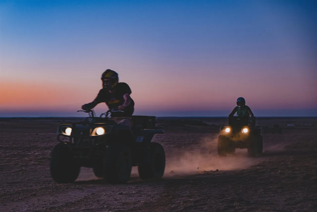Quad biking across desert dunes